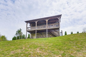 A two-story stone building with a balcony and stairs.
