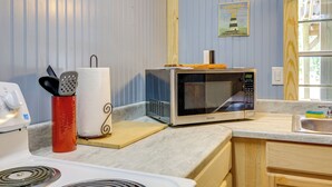 Keittiössä on mikroaaltouuni, punainen astiateline, puinen leikkuulauta ja kyltti, jossa kerrotaan majakkakierroksista.