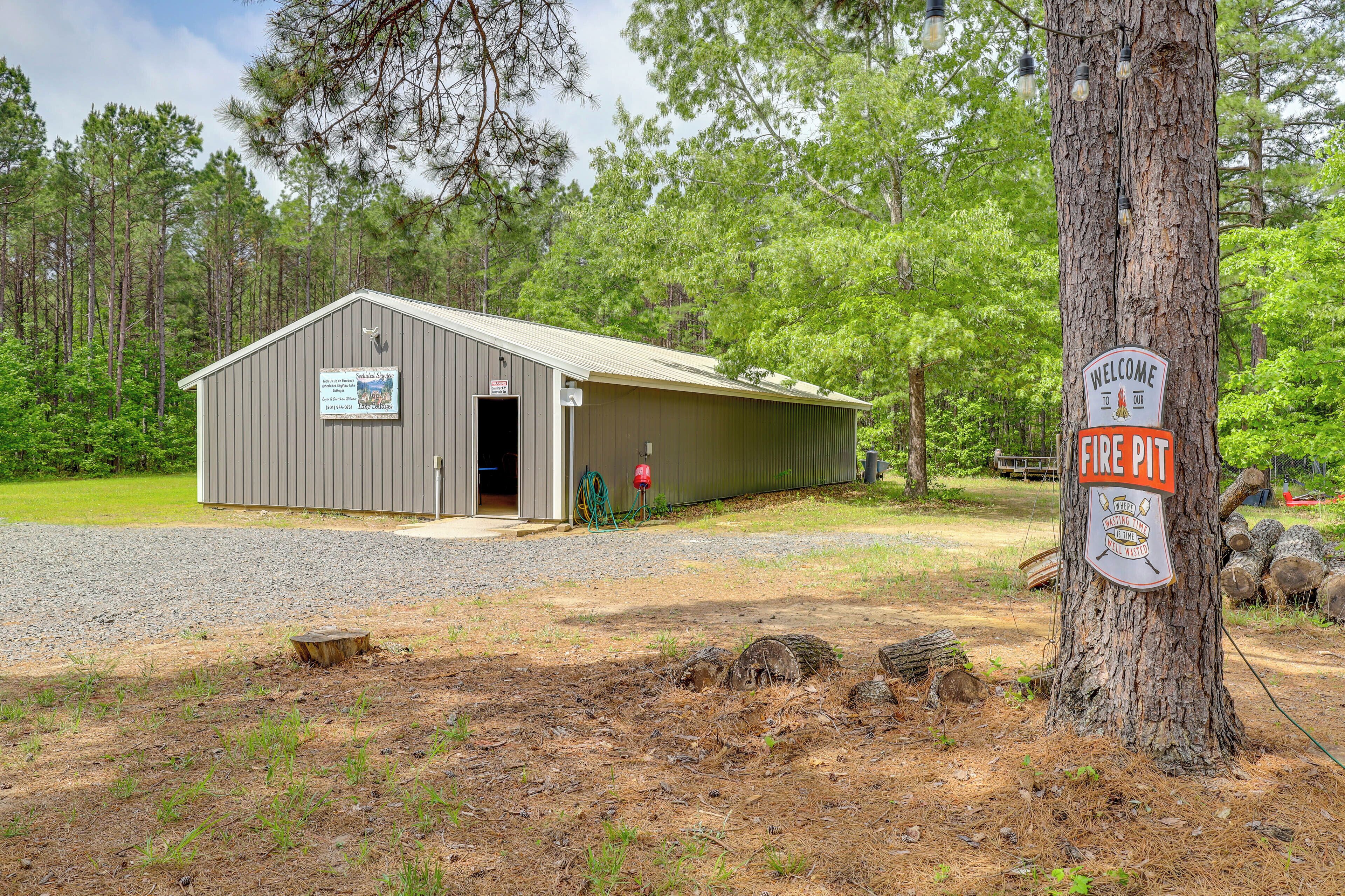A metal building with a door, labeled 'Fire Pit' and 'Welcome to Campground,' surrounded by trees.
