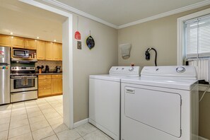 A kitchen with wooden cabinets, a microwave, an oven, and a washing machine. - Walk to Dtwn Brevard! Mtn Escape w/ Fire Pit (Brevard)