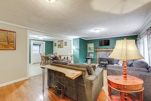 A living room with a sofa, a wooden coffee table, a lamp, and a television. - Walk to Dtwn Brevard! Mtn Escape w/ Fire Pit (Brevard)