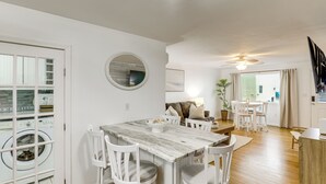 A modern kitchen with a marble countertop, white chairs, and a dining area with a table and chairs. - Steps to Shore! Family-friendly Getaway in Hampton (Hampton)