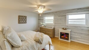 A bedroom with a bed, a dresser, a fireplace, and a ceiling fan. - Steps to Shore! Family-friendly Getaway in Hampton (Hampton)