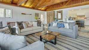 A spacious living area with two sofas, a coffee table, and a wooden ceiling. - A-frame Waterfront Escape on Lochada Lake (Glen Spey)