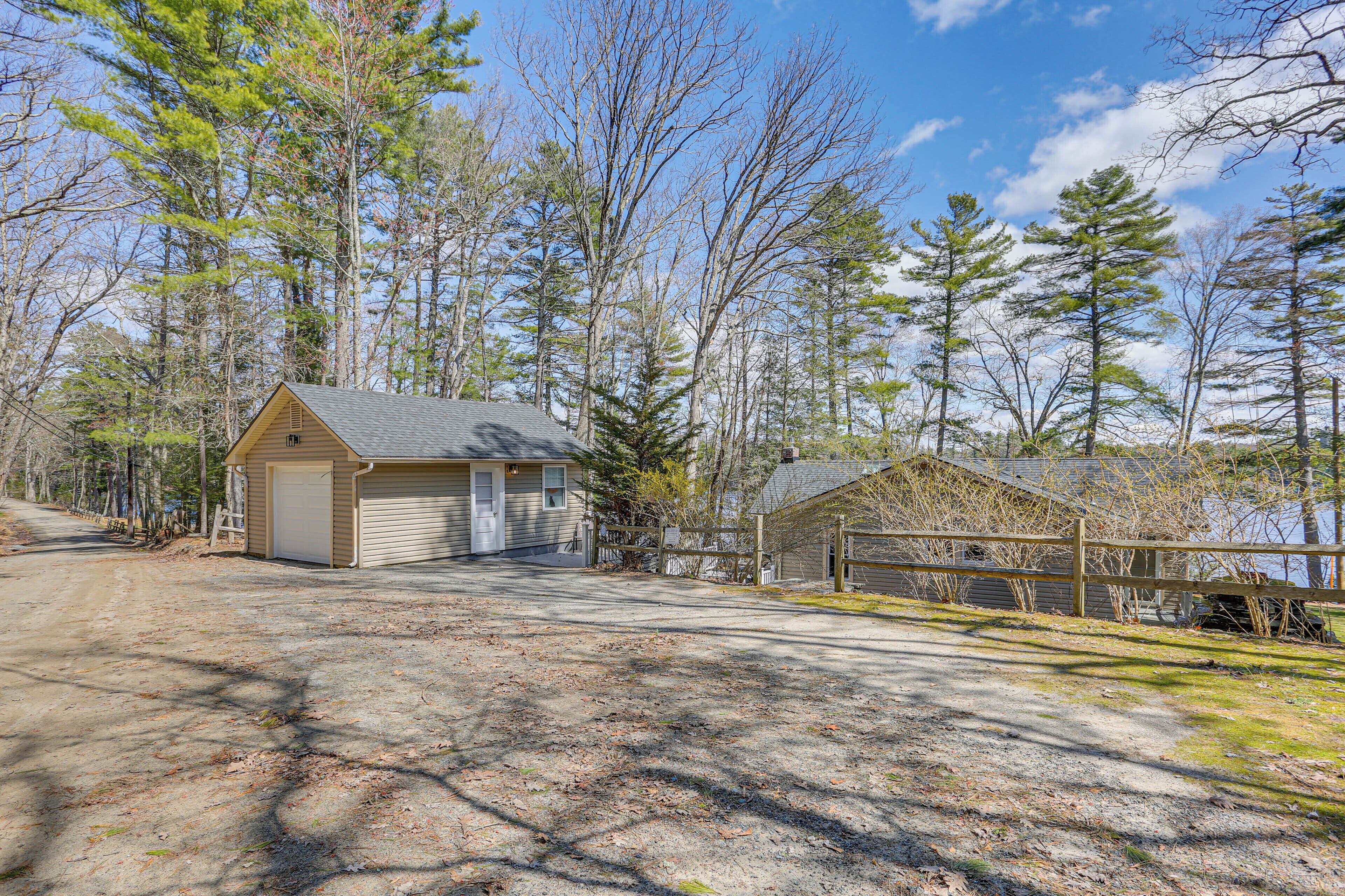 Une propriété située en zone rurale, comprenant un garage, un chalet en bois et une cour clôturée.