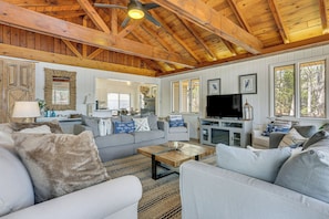 A spacious living area with a high ceiling, a television, and a fireplace. - A-frame Waterfront Escape on Lochada Lake (Glen Spey)