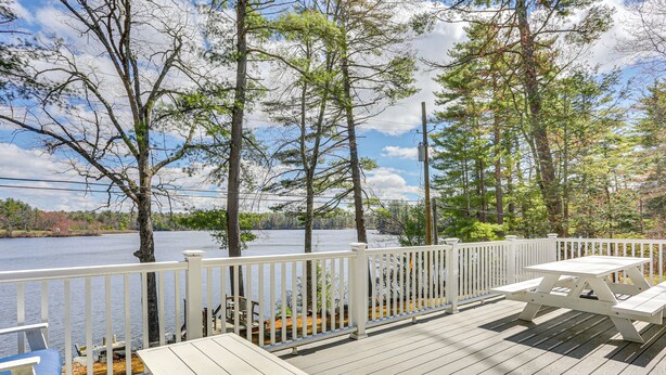 A wooden deck with picnic tables and a white railing overlooking a lake. - A-frame Waterfront Escape on Lochada Lake (Glen Spey)