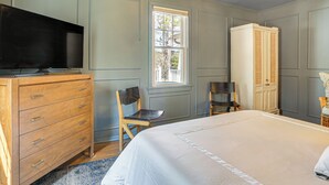 A bedroom with a bed, a dresser, a television, and a window. - A-frame Waterfront Escape on Lochada Lake (Glen Spey)