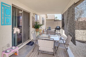 A patio with a table and chairs, a small pet feeding station, and a sliding glass door. - Dedicated Office! Casa Grande Extended Stay (Casa Grande)