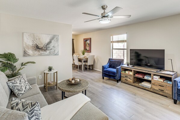A living room with a sofa, armchair, TV, and entertainment center.