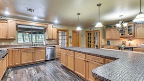 A kitchen with wooden cabinets, a stainless steel dishwasher, and a large window. - Walk to Lake Texoma: Family Home w/ Fire Pit! (Kingston)