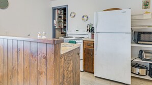 A kitchen with wooden cabinets, a white refrigerator, a microwave, and a stove. - Sunset Side of Seneca Lake! Family Home w/ Dock (Hector)