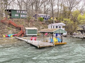 A dock with a small structure, a staircase, and a row of colorful Adirondack chairs. - Sunset Side of Seneca Lake! Family Home w/ Dock (Hector)