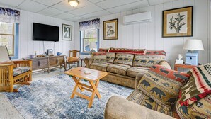 A living room with a sofa, a TV, a wooden coffee table, and a patterned rug. - Sunset Side of Seneca Lake! Family Home w/ Dock (Hector)