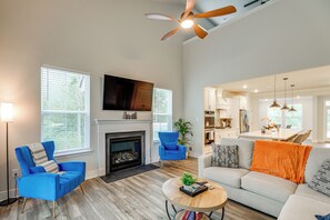 Een moderne woonkamer met een open haard, een televisie en een eethoek.