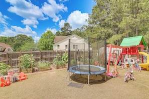 A backyard with a trampoline, playset, and a house. - Families Welcome! Spacious Loganville Gem w/ Yard (Loganville)