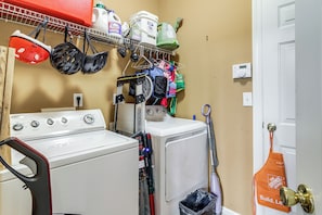 A laundry area with a washing machine, a dryer, and various cleaning supplies. - Families Welcome! Spacious Loganville Gem w/ Yard (Loganville)