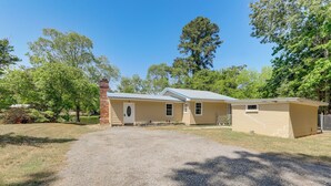 A two-story building with a gravel driveway, a brick chimney, and a small attached structure.