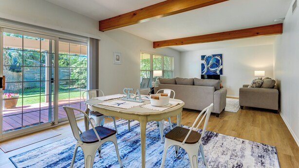 A dining area with a table, chairs, and a view through glass doors to an outdoor patio.