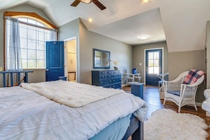 A bedroom with a large bed, a dresser, a chair, and a desk.