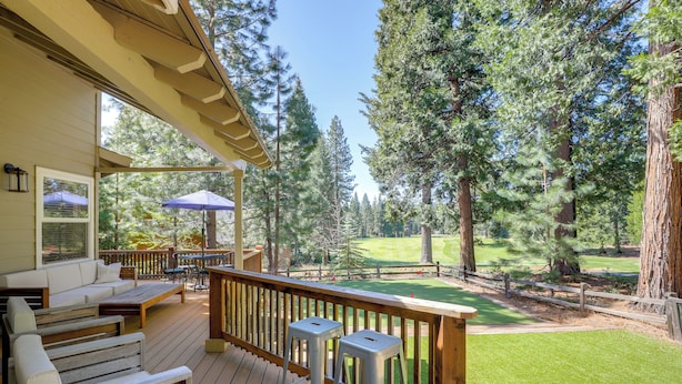 A wooden deck with outdoor seating, a view of a golf course, and tall pine trees. - Game Room & On-site Golf Course! Lake Almanor Home (Westwood)