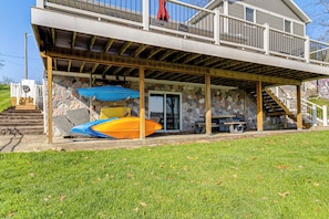 A two-story house with a covered patio, stone walls, and a staircase leading to the upper level.