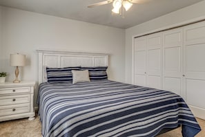 A bedroom with a bed, a nightstand, a lamp, and a closet. - Private Dock & Large Deck! Jimmerson Lake Escape (Angola)