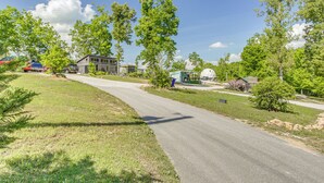 A residential street with houses, trees, and a clear sky. - Tiny Cabin Getaway in the Tennessee River Valley (Rogersville)