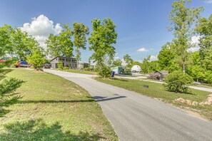 A residential street with houses, trees, and a clear sky.