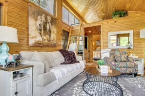 A cozy interior with a sofa, patterned armchair, and a round coffee table.