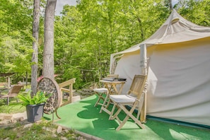 A tent with a table and chairs, surrounded by trees. - Creekside Couple's Glamping Retreat in Rogersville (Rogersville)