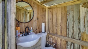 A rustic wooden bathroom with a sink, mirror, and toilet. - Unique Glamping Tent in Tennessee River Valley (Rogersville)