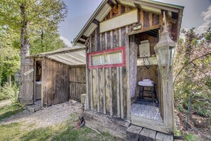 A rustic wooden cabin with a 'Welcome' sign, a small porch, and a window with a decorative frame.