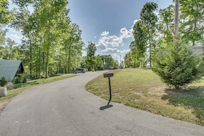 A residential street with a mailbox, parked cars, and houses.