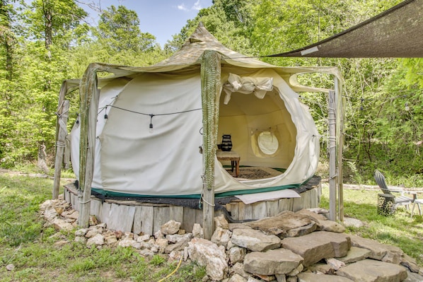 A small, enclosed tent with a sleeping area, a table, and a chair.
