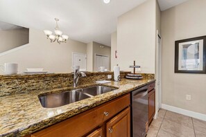 A kitchen with granite countertops, stainless steel sink, wooden cabinets, and a chandelier. - Private Pool·Lake View·BBQ·Mins to Disney (Kissimmee)