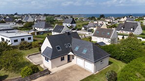 Un quartier résidentiel où les maisons sont dotées de toits à pignon, d’une allée et offrent une vue sur la mer.