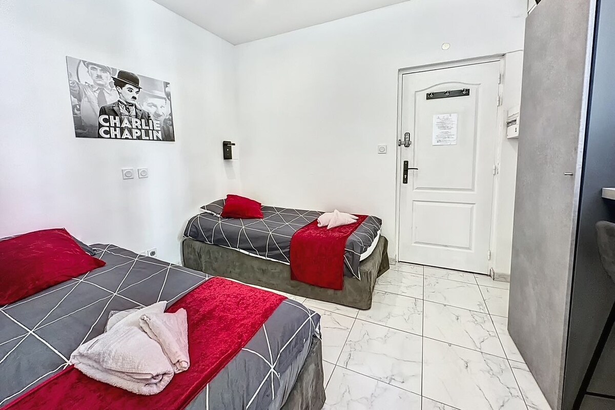 Una habitación de hotel con dos camas, una puerta y un cartel en la pared.