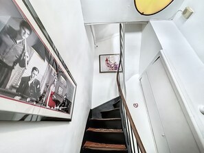 A staircase with a handrail, a framed picture on the wall, and a door with a no-smoking sign. - Sweet Home Marceau (Cannes)