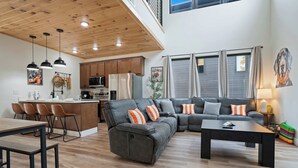 A modern living space with a kitchen, dining area, and seating area.