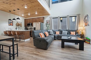 A modern living space with a kitchen, dining area, and seating area.