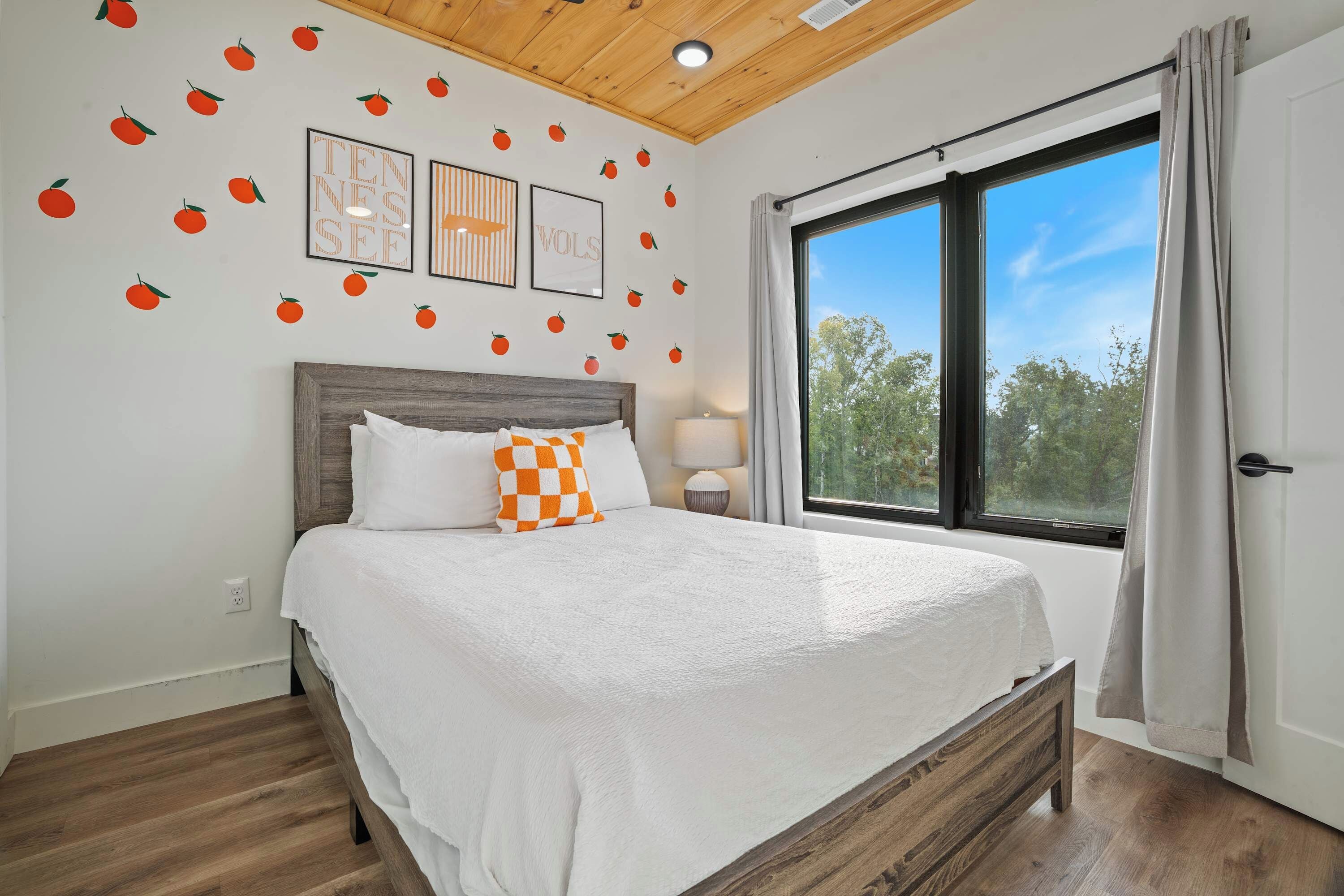 A bedroom with a bed, a window, and wall decorations.