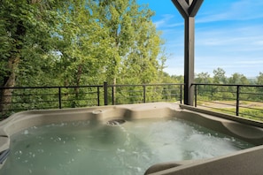 A hot tub with a view of a forested area.