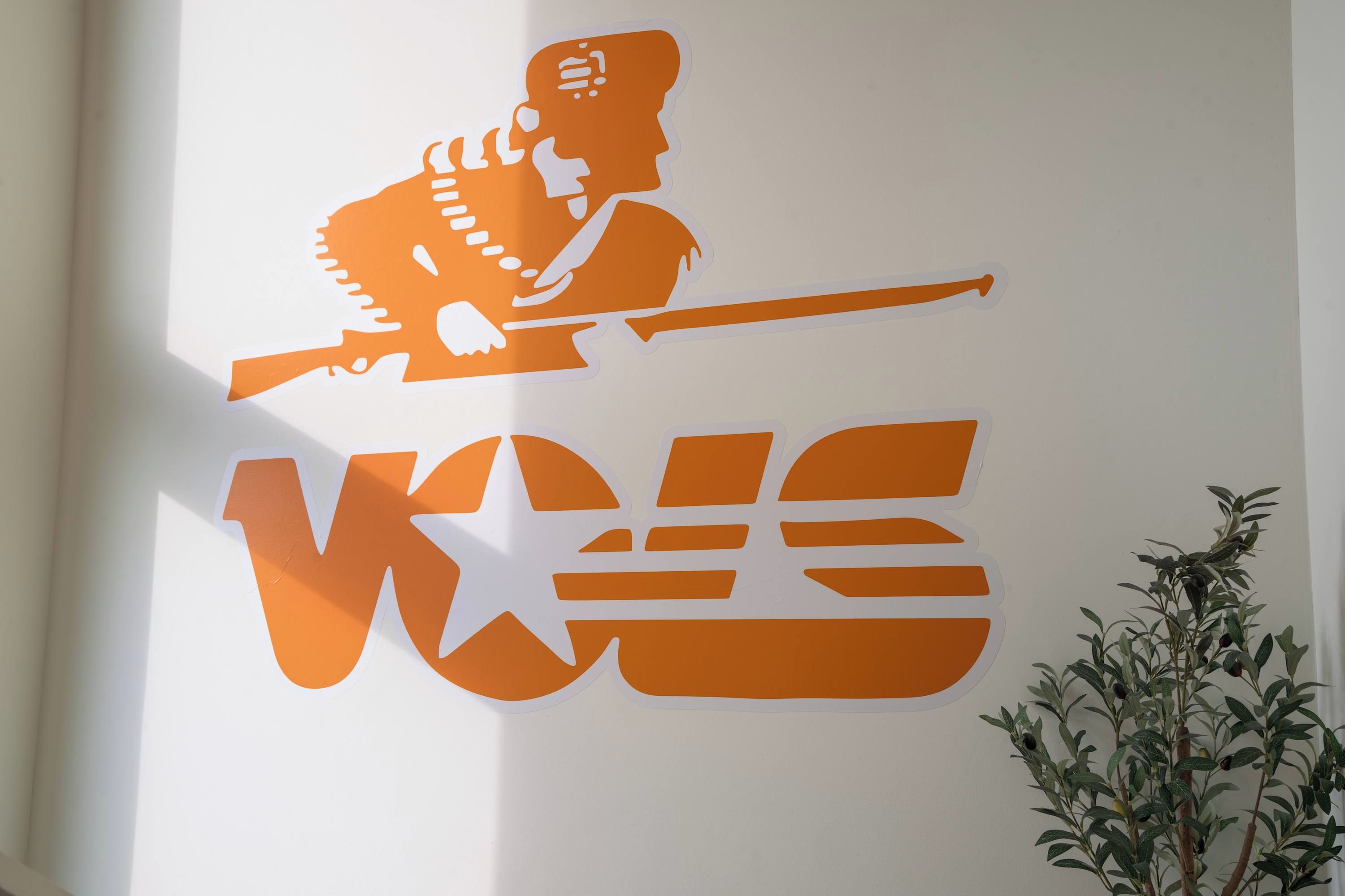 A wall with a large, stylized logo featuring a figure with a rifle.