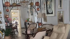 A living room with a sofa, chairs, a dining area, and a chandelier. - Casa Grande (Coín)