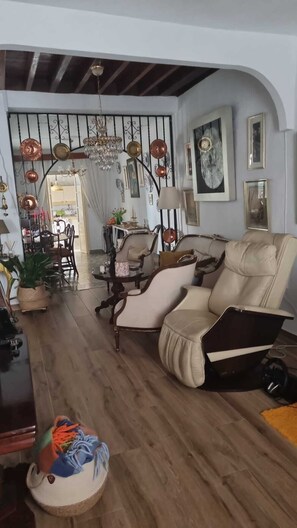 A living room with a sofa, chairs, a dining area, and a chandelier. - Casa Grande (Coín)