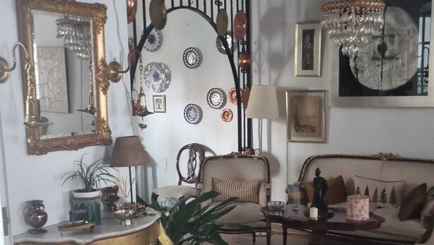 A living room with a wooden ceiling, a sofa, a chair, a table, and decorative plates on the wall. - Casa Grande (Coín)