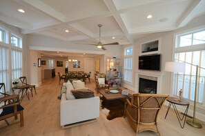 A spacious living room with a fireplace, a ceiling fan, and a television. - Elegant Single Family Home With Private Pool! (Rehoboth Beach)