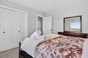 A bedroom with a bed, a large mirror, and a view of the outdoors through a window. - Sweet Esmeralda-FirePit, BBQ, Pets OK, Fenced Yard (Nampa)