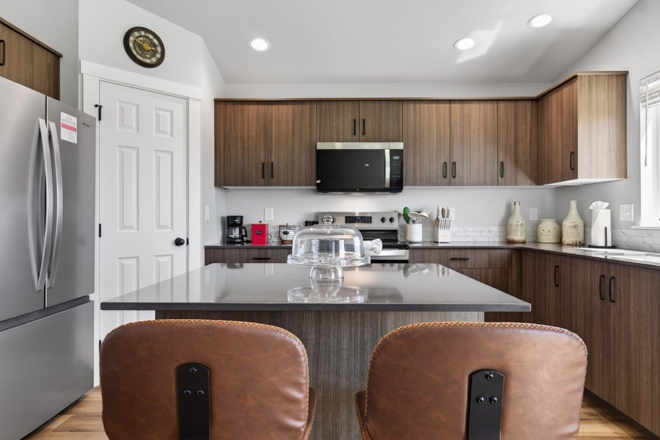 Une cuisine moderne avec des meubles en bois, des appareils en acier inoxydable et un îlot central.